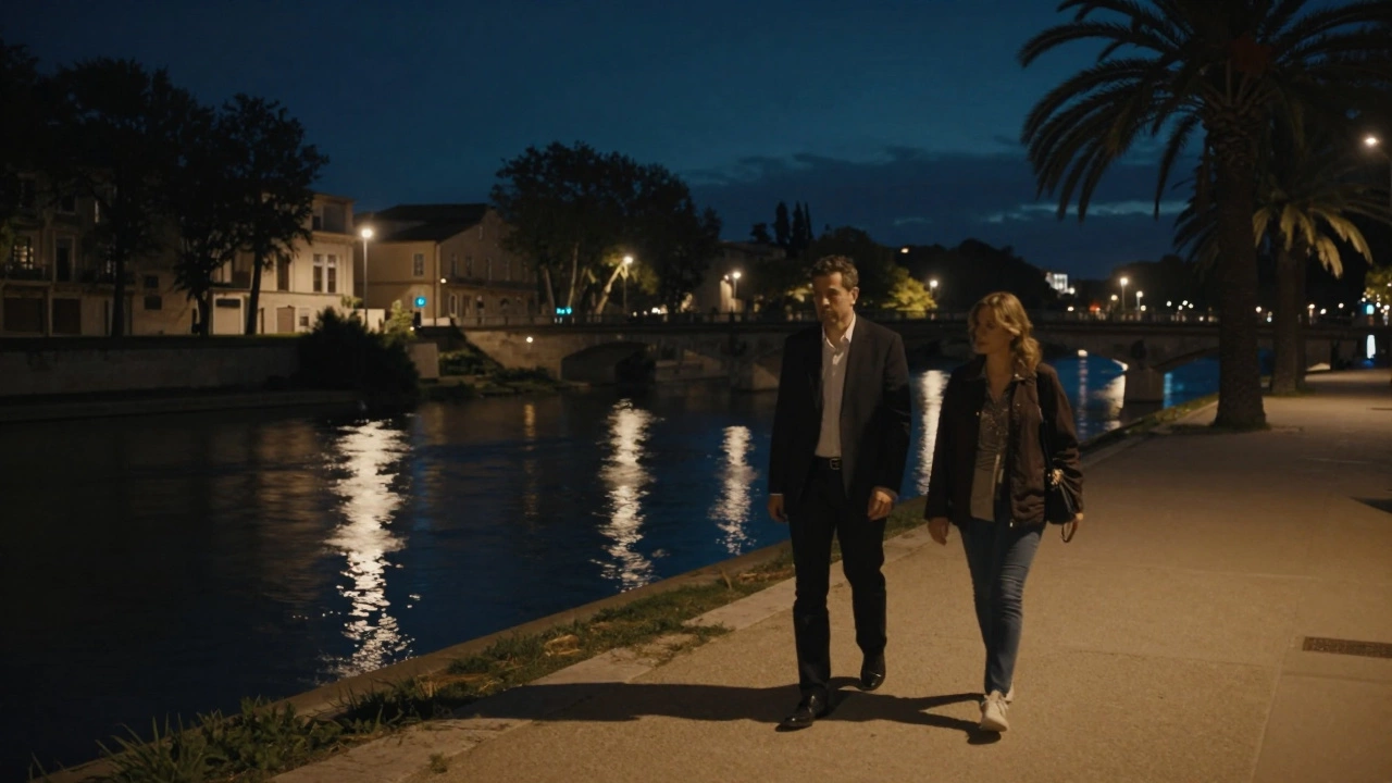 A couple walking peacefully along the Lez River at night.